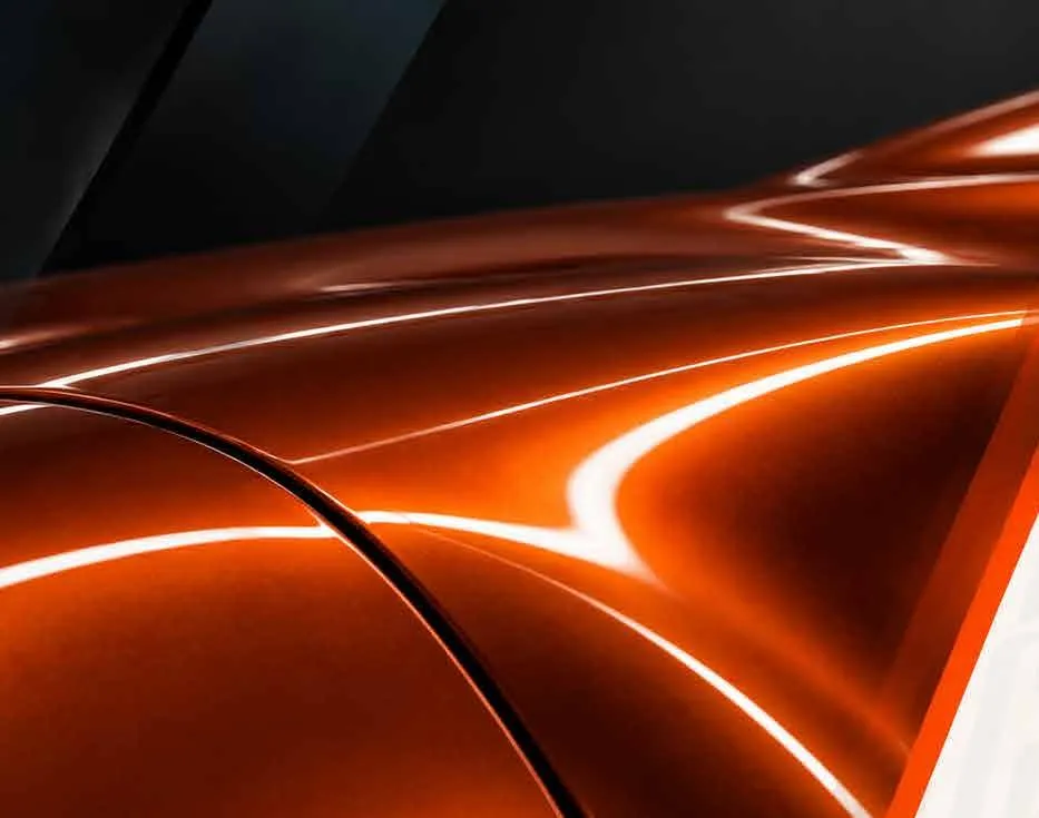 Detalle de una carrocería naranja con reflejos